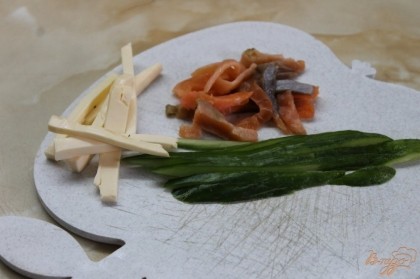 Лосось, огурец и сыр плавленный нарезать средней соломкой.