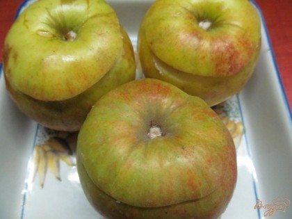 Накрыть яблоки срезанными верхушками и выложить в форму для запекания.
