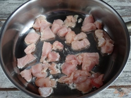 Куриную грудку порезать кусочками, выложить в разогретое масло на сковороду. Обжарить 5-7 минут, пока мясо не побелеет.