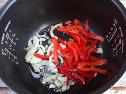 Порежьте репчатый лук и болгарский перец. Выложите овощи вместе с постным маслом в мультиварочную чашу. При помощи программы «Жарка» обжарьте их в течение 5-6 минут.