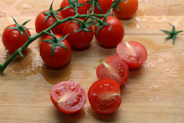Вымытые помидоры черри разрежьте пополам. 