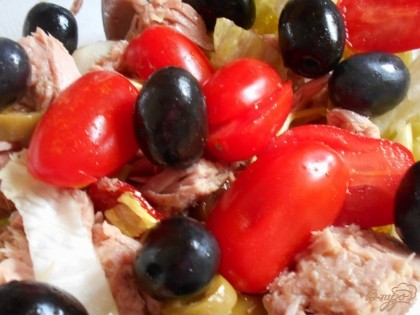 Помидорки черри разрезаем на половинки или четвертинки и выкладываем в салатник вместе с черными оливками.
