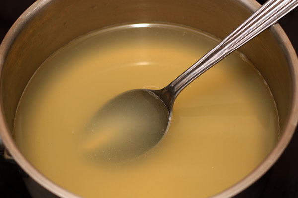 Филе выньте из бульона, а бульон процедите через несколько слоев марли.   Можно осветлить бульон с помощью сырого яйца, для этого слегка взбитое яйцо влейте в бульон, тщательно перемешайте и доведите до кипения. Затем удалите яичные хлопья, а бульон процедите.  Желатин замочите на несколько минут в небольшом количестве холодной кипяченой воды, добавьте в теплый бульон и размешайте до растворения.
