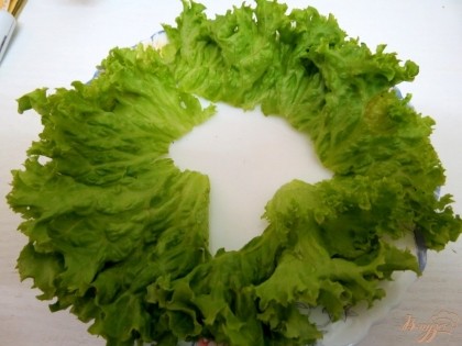 В тарелочке по кругу выкладываем листья салата.