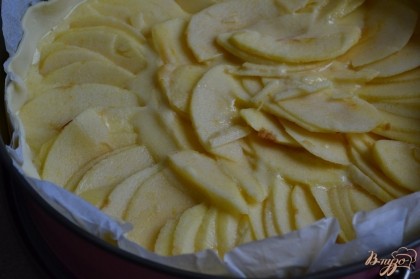 Готовое слоеное тесто выложить в форму, дно наколоть вилкой.Вылить смесь-заливку и разложить тонкие яблочные дольки.