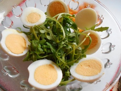 Теперь выкладываем ингредиенты в салатник. На дно кладем любой салат. По краю салатника- кружочки яиц.