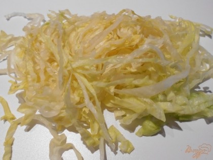 Капусту нарезать узкими тонкими полосками и выложить в салатник.