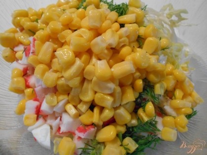 Добавляем в салат зелень и консервированную кукурузу.