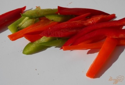 Длинными полосками нарезаем и болгарский перец. Лучше взять перец разных цветов. В сковородку наливаем оливковое масло, прогреваем его и обжариваем овощи на сильном огне 4-5 минут.