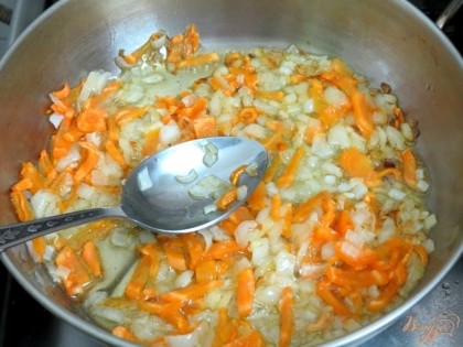 Лук и морковь выкладываем на разогретую сковороду с растительным маслом.Пассеруем на маленьком огне.
