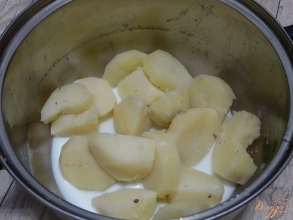 С отварного картофеля слить всю воду, добавить теплое молоко.