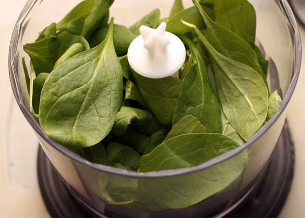 Фисташки положите в блендер, добавьте листья свежего шпината.