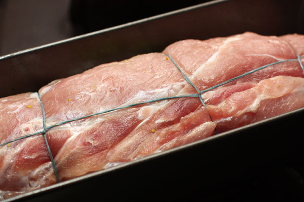 Сверните мясо в виде рулета и обвяжите его толстой хлопковой нитью. Положите в подходящую форму для запекания (не слишком большую), накройте фольгой и поставьте в разогретую духовку.