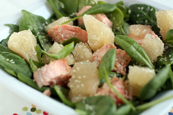На тарелках разложите смесь зелени с заправкой, сверху выложите рыбу и помело. Для украшения можно посыпать мелко нарезанной кинзой или кунжутом.