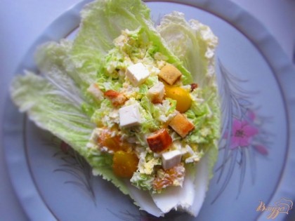 Выложить салат на листья капусты и сверху выложить сыр и сухарики, для красоты.