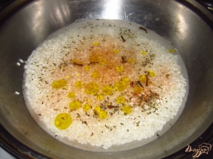 Налейте в сковороду воду, всыпьте соль,гвоздику, базилик, добавьте оливковое масло 1ст.л. Так же положите дольки неочищенного чеснока. Варите рис на медленном огне под закрытой крышкой.