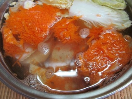 В кастрюлю с горячей водой выложить чищенный картофель, сельдерей, морковь и пекинскую капусту. Посолить и варить до готовности.