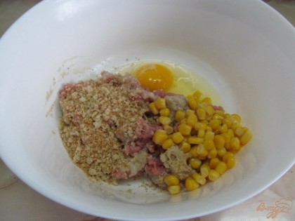 В фарш вбить яйцо, добавить панировочные сухари, кукурузу, посолить и поперчить.