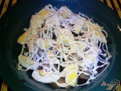 Готово! Выложить в салатник морскую капусту, зелёный лук, кусочки яиц и шпротов. Сверху сделать сеточку из майонеза (совсем небольшое количество). Всё - наш салат готов!