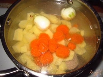 В кипящую воду положите картофель, две очищенные луковицы и нарезанную на кусочки морковь, посолите. Варите минут 15.
