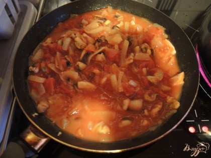 К морепродуктам добавляем томаты. Чтобы облегчить приготовление блюда, лучше использовать резаные томаты. Протушиваем нашу зажарку, пока не выкипит излишек воды.