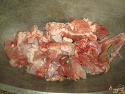 Мясо кролика порезать кусочками и уложить в казан. Жарить на подсолнечном масле.