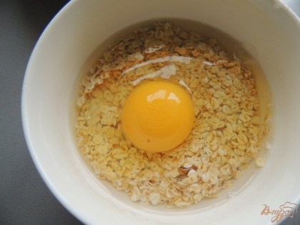 В небольшой чаше овсянку соединяем с яйцом и водой, хорошенько перемешиваем и оставляем разбухать на 25-30 минут.