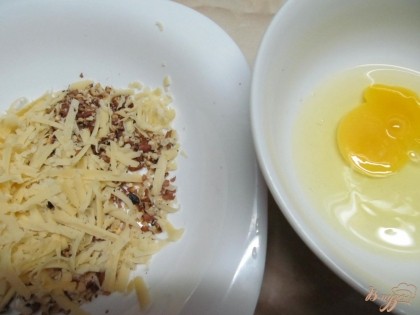 Сыр натереть на терке и смешать с орехами. Яйцо взбить вилкой в отдельной тарелке. Муку насыпать в отдельную тарелку.