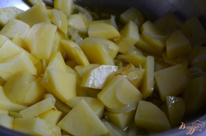 В кастрюле обжарить кусочки картофеля и луковицу на оливковом масле в течении 5 минут.Залить бульоном. Варить до  готовности картофеля.