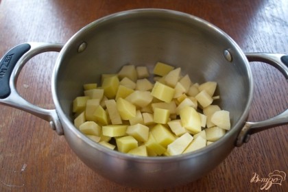 Картофель очистить. Нарезать кубиком. Залить водой и дать закипеть. Рис промыть и добавить к картофелю. Варим 10 минут.