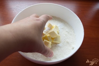 В миску просеять муку. Добавить сахар, соль, разрыхлитеть и перемешать руками. Нарежьте сливочное масло холодное. Смешайте его руками с мукой до состояния крошки.