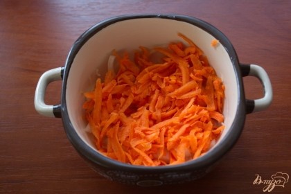 Морковь натираем на терку и выкладываем сверху на лук.