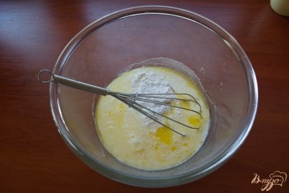 К слегка остывшему маслу влейте молоко, добавьте сахар, разрыхлитель, яйцо. Взбейте массу до однородности.