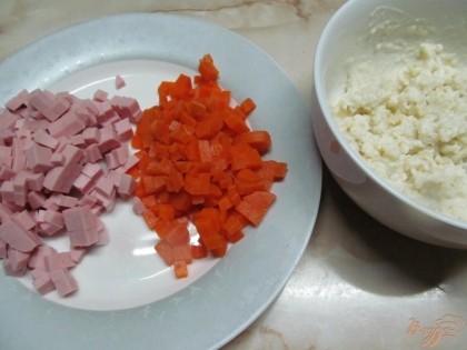Колбасу и морковь мелко нарезать. Соединить сметану, майонез, чеснок (пропущенный через пресс) и горчицу. Одну ложку добавить в картофель и перемешать.