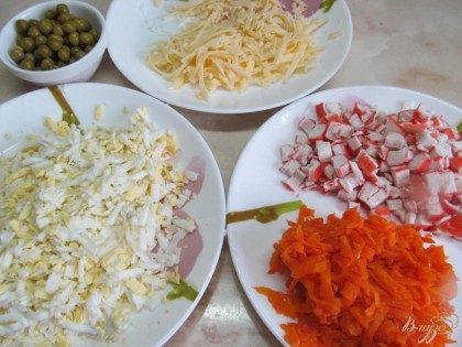 Крабовые палочки мелко нарезать, а морковь, яйца и сыр натереть на крупой терке.