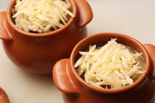 Разлейте суп по порционным горшкам, в каждый положите сверху по кусочку поджаренного багета, посыпьте сыром и поставьте в разогретую до 200 градусов духовку на 5-7 минут, чтобы сыр расплавился.