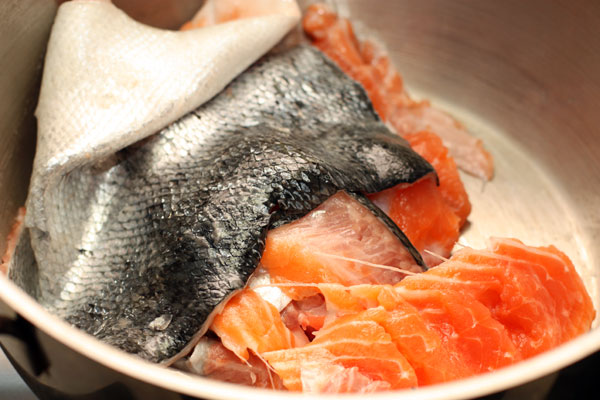 Возьмите рыбу и отделите филе. Шкуру, кости и плавники (если есть голова, то ее тоже) сложите в большую суповую кастрюлю.