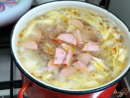 Колбасу и пассерованные овощи отправляем вариться в суп. Солим и перчим суп. Огонь должен быть маленький. Суп должен томиться, а колбаса должна отдать супу свой аромат. Добавляем в суп зелень.