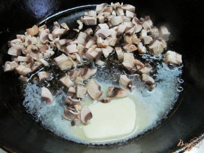 В сковороду влить растительное масло и 25 грамм сливочного масла и жарить грибы на среднем огне.