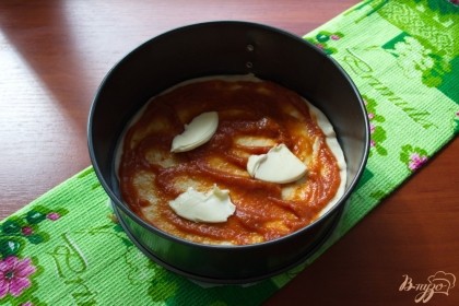 Теперь, смазываем тесто томатным соусом. Нарезаем тонко сливочное масло и выкладываем поверх томатного соуса.