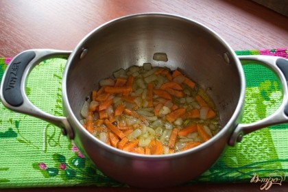 Нарежьте морковь и добавьте ее к луку. Обжарьте все вместе.