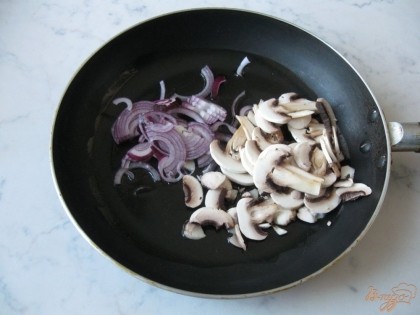 На сковороду наливаем масло, выкладываем половину нарезанного лука, нарезанные грибы и ставим тушить.