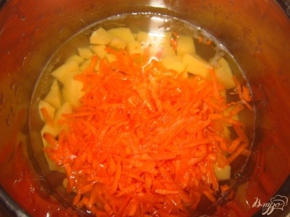 В кастрюлю влейте воду, доведите до кипения. Положите в кастрюлю мелко нарезанный картофель и натертую морковь. Варите минут 15, посолить.