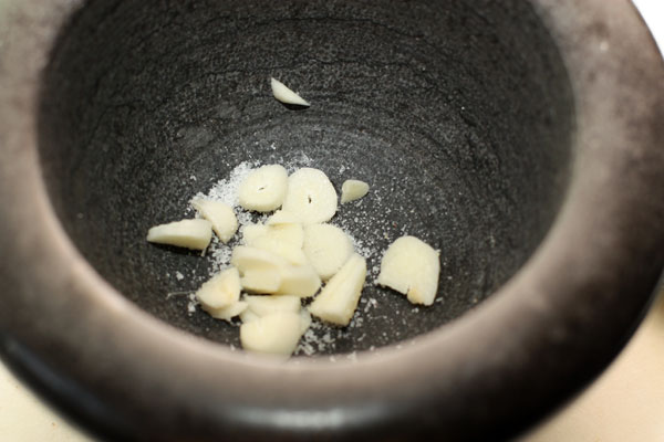 Растолките в ступке чеснок с крупной солью до однородной пасты.
