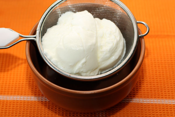 Густой йогурт выложите на сито и дайте стечь лишней жидкости в течение получаса или дольше. Затем смешайте йогурт с толченым чесноком и хорошо перемешайте.