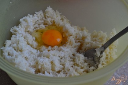 Рис отварить до готовности,немного остудить и  переложить в салатник, выбить 1 яйцо.Добавить соль и специи по вкусу.