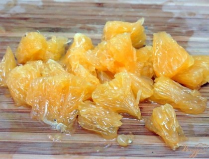 Разделываем вторую половину апельсина, очищаем дольки от плёночек, разделяем на кусочки.