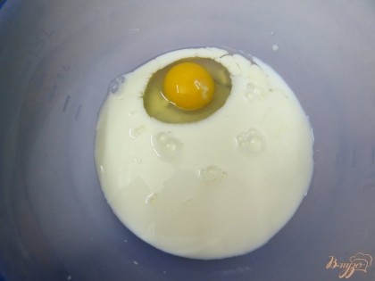К яйцу добавляем молоко. При помощи венчика соединяем молоко с яйцом.