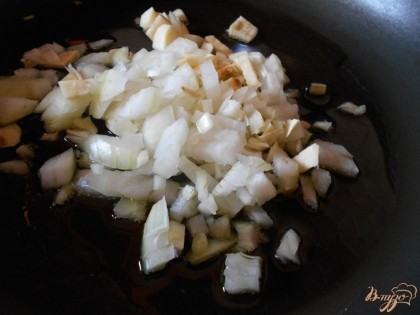 Лук и чеснок нарезаем мелким кубиком и обжариваем на оливковом масле до мягкости лука.