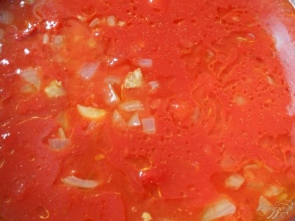 Добавляем обжаренные овощи к томатам и ставим кастрюлю на огонь. Даем томатам закипеть и убавим огонь до минимума. Оставляем томаты тушиться до готовности.